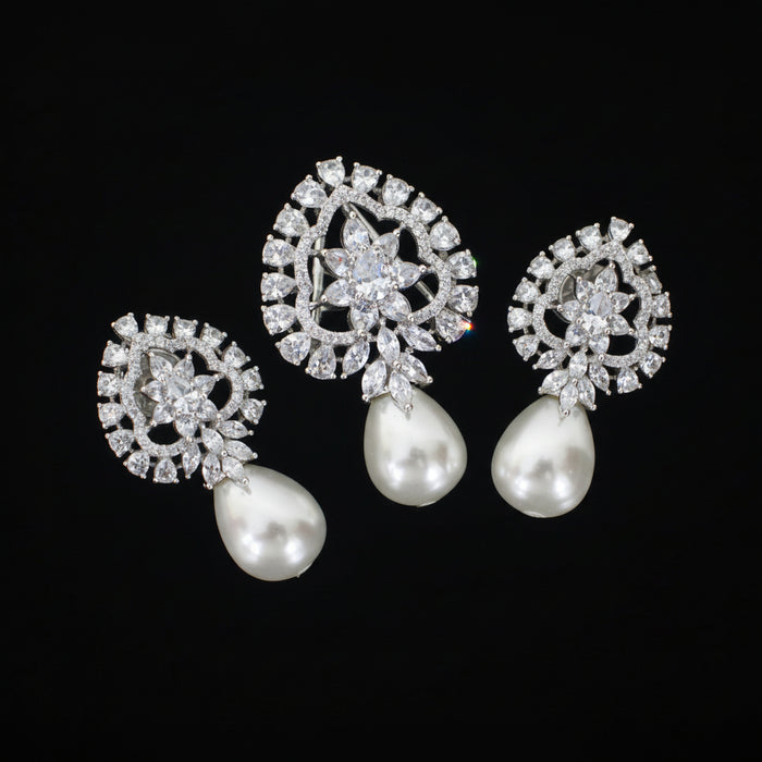 Pair of silver earrings with pearl drops on a black background