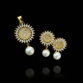 Gold and pearl earrings on a dark surface with 'SAHELI' branding.