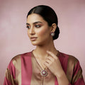 Jewelry set with pendant and earrings on a dark background, featuring the brand 'Saheli'.
