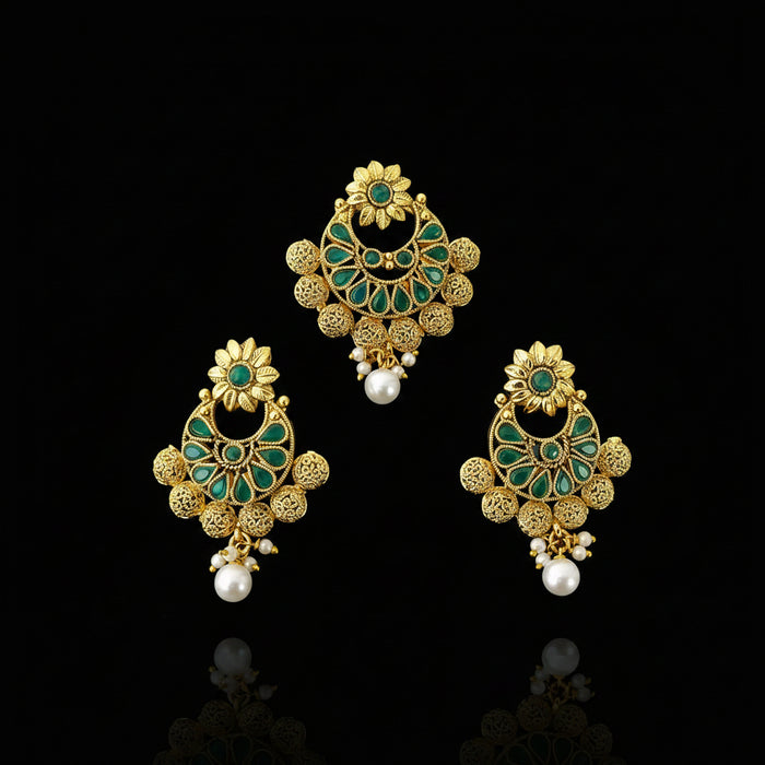 Gold and green earrings with pearl accents on a dark background, featuring the brand 'SAHELI'.