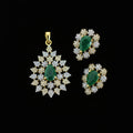 Jewelry set with green stones and gold accents on a dark background, featuring the brand 'Saheli'.