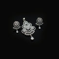 Silver jewelry set with pendant and earrings on a dark gray background
