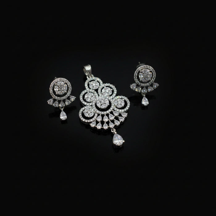 Silver jewelry set with pendant and earrings on a dark gray background
