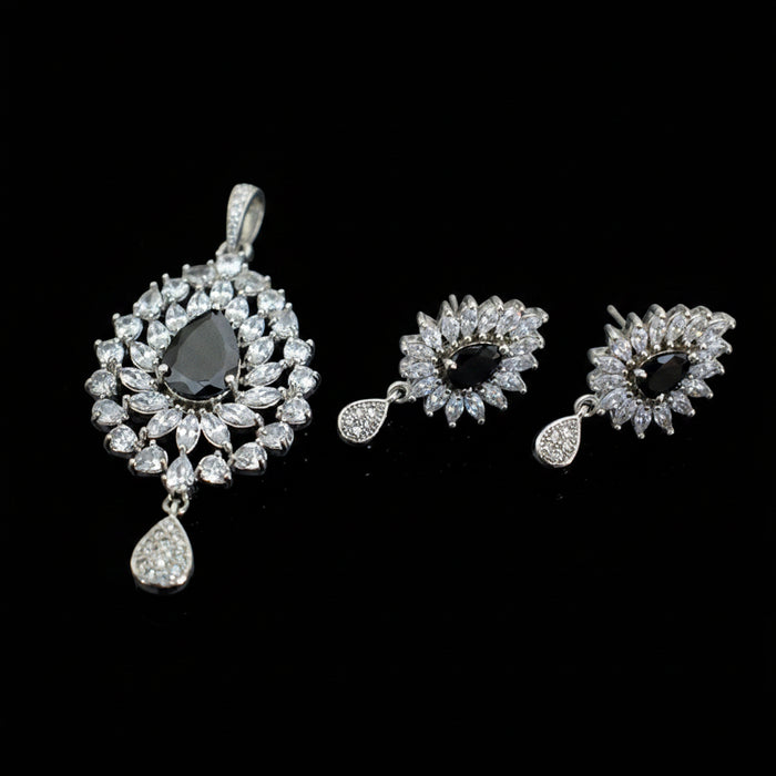 Jewelry set with earrings and a pendant on a dark background, featuring the brand 'Saheli'.
