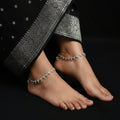 Silver necklace with floral design on a dark background