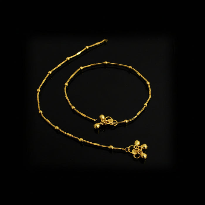 Gold anklets on a black background