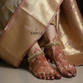 Gold necklace and bracelet set with 'Saheli' branding on a dark background