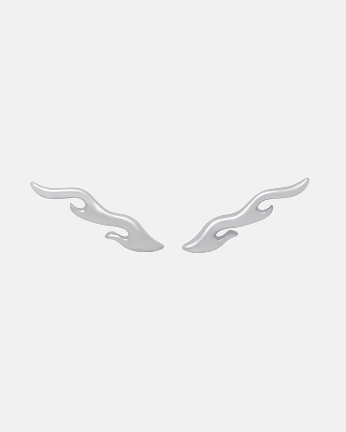 The Statement Collective "Pyro" Flame Earrings—two silver, wavy double-flame studs—are displayed symmetrically on a plain light gray background, highlighting their mirrored abstract design and bold style.