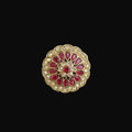 Decorative brooch with red gemstones and gold accents on a dark background