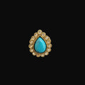 Ring with turquoise stone and gold accents on a dark gray background