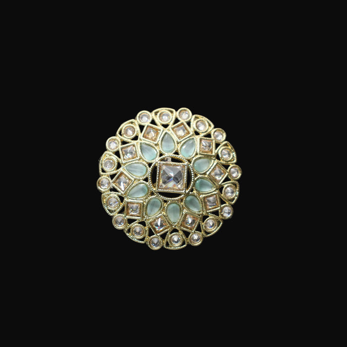 Decorative ring with gemstones on a black mannequin hand against a dark background