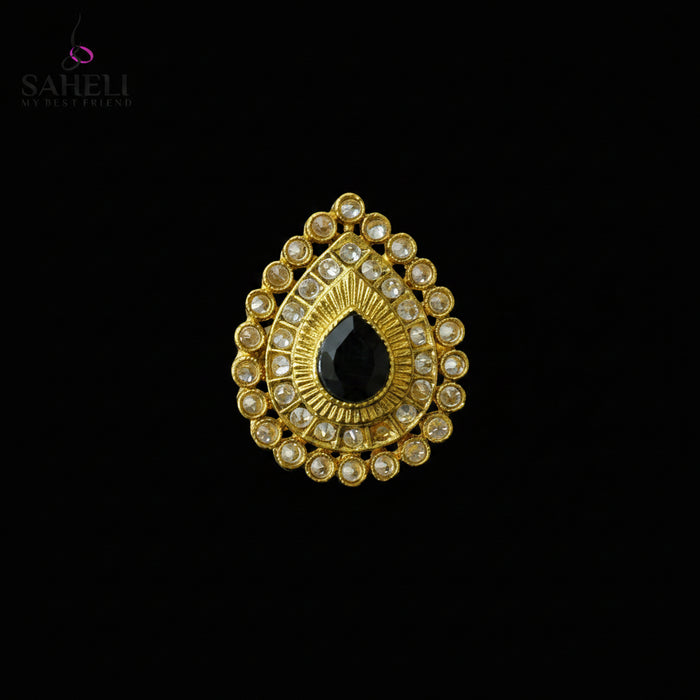 A gold teardrop-shaped traditional Indian jewelry piece featuring a central black teardrop stone surrounded by clear stones, displayed on a dark gray background with a SAHELL MY BEST FRIEND logo in the top left corner.