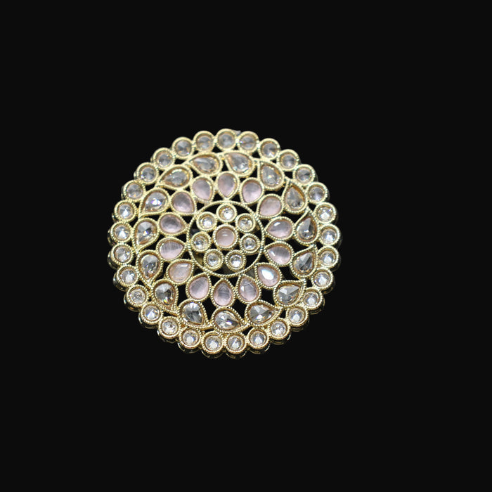 Gold ring with gemstones on a black mannequin hand against a dark background