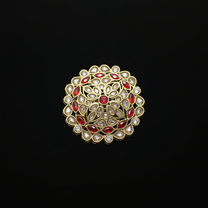 Decorative ring with red gemstones on a black mannequin hand against a dark background