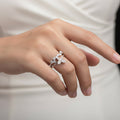 Silver butterfly ring on a black mannequin hand with a gray background