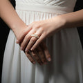Gold and diamond ring on a black gloved hand with 'SAHELI' branding.