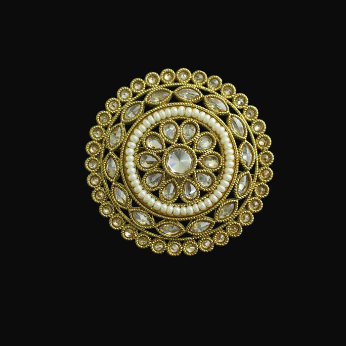 Decorative ring with gold and pearl design on a dark background