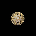 Gold ring with intricate design on a black mannequin hand
