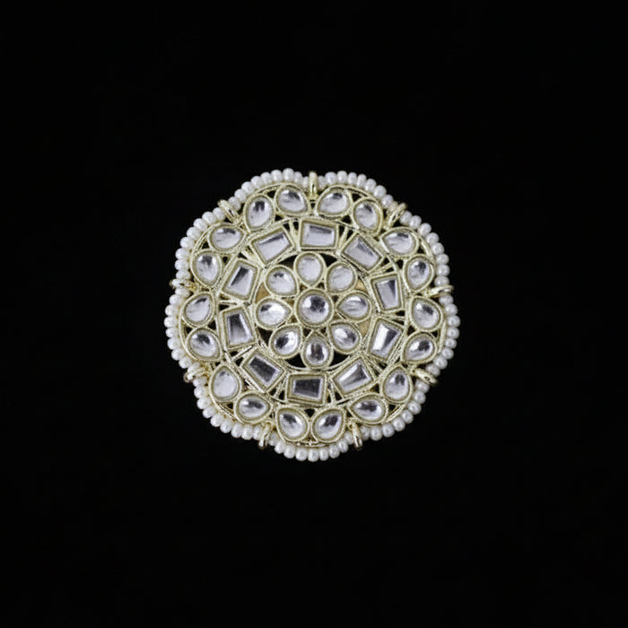 Decorative ring with gemstones on a black glove against a dark background