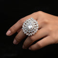 A large ornate silver-toned statement ring with a teardrop-shaped clear crystal and surrounding clear stones, displayed on a black gloved hand against a black background. The brand name 'SAHeli My Best Friend' is visible as an overlay.