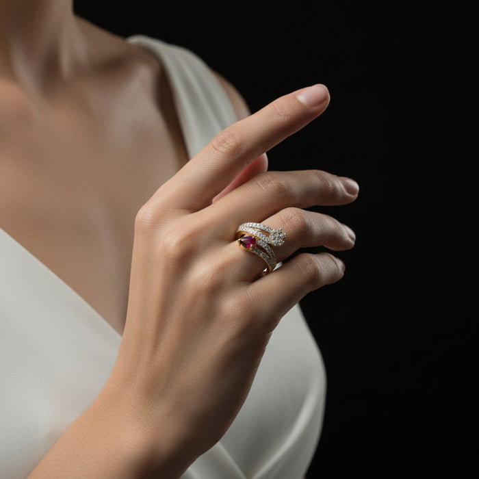 Gold and diamond ring with a red gemstone on a dark background, branded 'Saheli'.