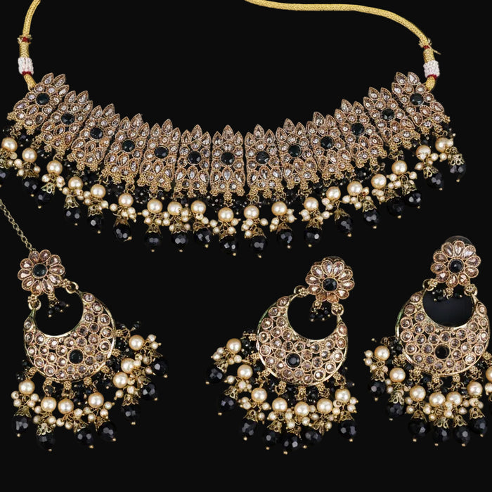 Jewelry set with necklace and earrings on a dark background, featuring the brand 'Saheli'.
