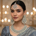 Silver necklace and earrings set on a dark background