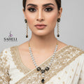 Jewelry set with necklace and earrings on a gray background, featuring the brand 'SAHELI'.
