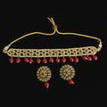 Gold necklace with red stones and matching earrings on a dark background