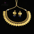 Gold coin necklace and matching drop earrings displayed on a dark reflective surface. The necklace features multiple rows of gold coins, small gold beads, and dark blue stone accents, with a gold cord closure.