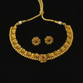 Gold necklace and earrings set on a dark background