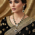 Jewelry set with necklace and earrings on a dark background, featuring the brand 'Saheli'.