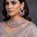 Jewelry set with purple stones on a black background, featuring the brand 'Saheli'.