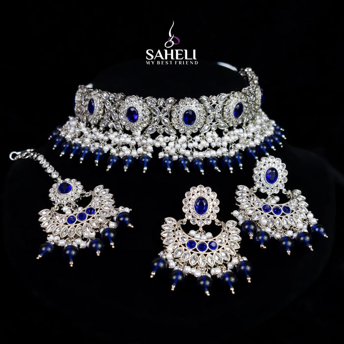 Jewelry set with necklace, earrings, and choker on a black background with 'Saheli' branding.