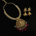 Gold necklace with red beads and matching earrings on a black background, branded 'SAHELI'.