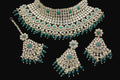 Green and gold jewelry set on a dark background