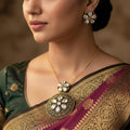 Ornate gold and black earrings with clear stones on a dark background, featuring the brand 'Saheli'.