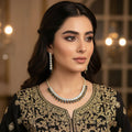 Gold and black necklace with matching earrings on a dark background, branded 'Saheli'.