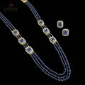 A three-strand beaded necklace and matching stud earrings set by Saheli My Best Friend. The jewelry features dark blue beads, rectangular blue inlays, and gold spacer beads set in silver-tone borders, displayed on a reflective gray surface.