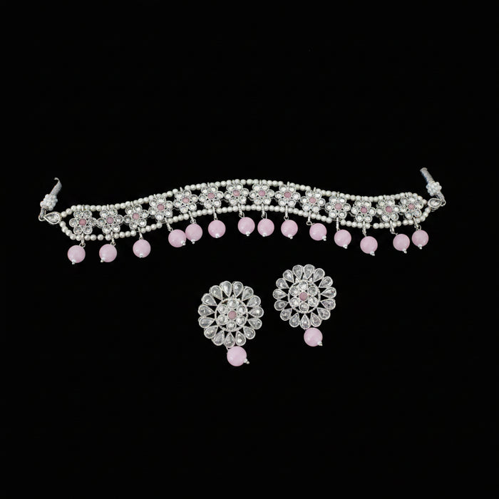 Jewelry set with necklace and earrings on a dark background, featuring the brand 'Saheli'.