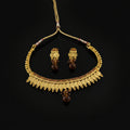 Gold-toned traditional necklace and matching earrings with amber-colored teardrop beads, displayed on a dark reflective surface. The necklace features gold coin-like disc elements, beaded borders, and small red gemstone accents.