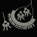 Silver jewelry set including necklace, earrings, and tikka on a dark background