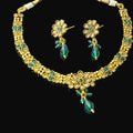 Gold necklace with green beads and matching earrings on a gray background, featuring the brand 'Saheli'.