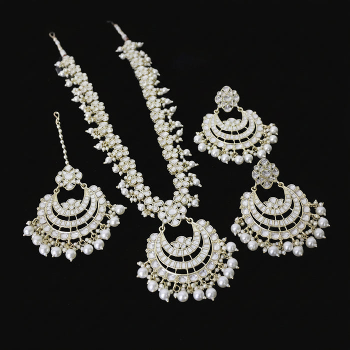 Set of gold and pearl jewelry on a dark background