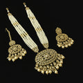 Ornate gold and pearl necklace with matching earrings on a reflective black surface