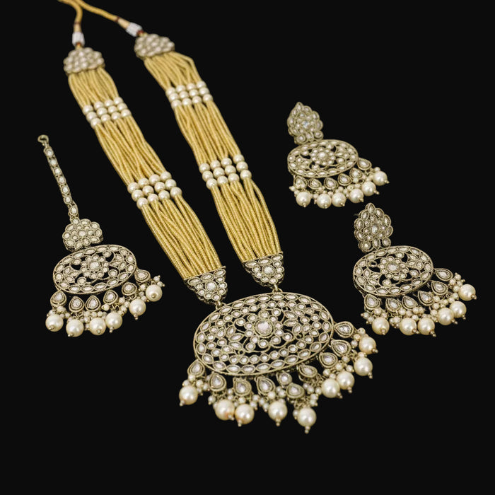Ornate jewelry set with earrings and a necklace on a dark background