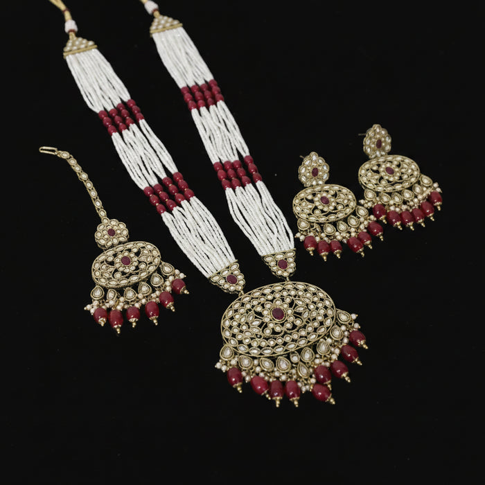 Jewelry set with gold, red, and white elements on a dark background