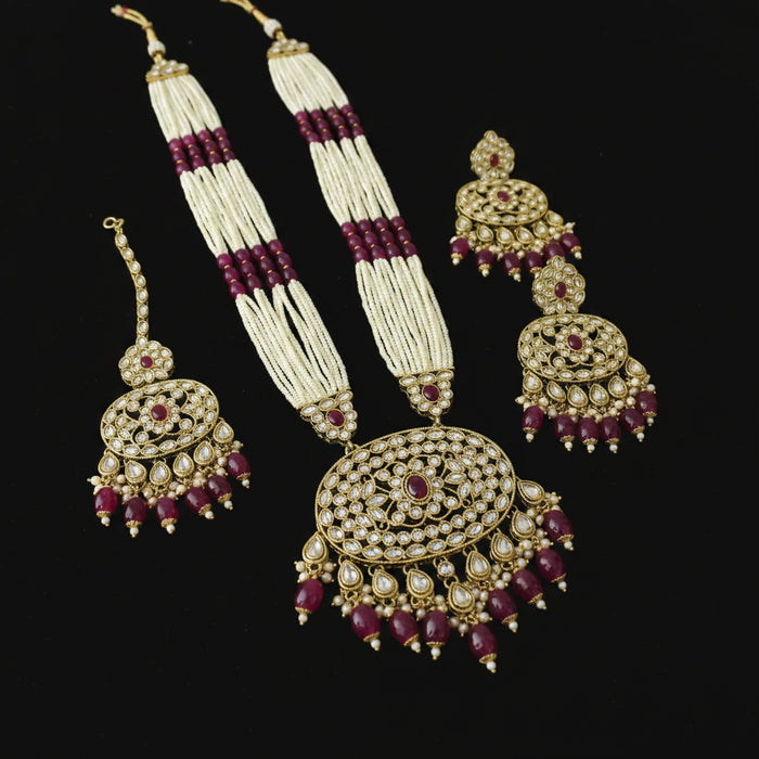 Gold and green jewelry set on a reflective surface