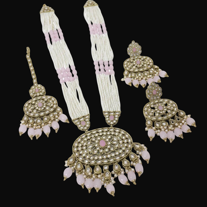 Set of traditional jewelry including earrings and a necklace on a reflective surface.