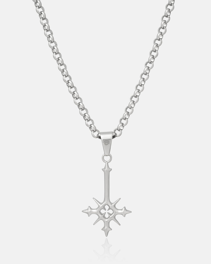 Silver inverted cross pendant with spikes hanging on white background
